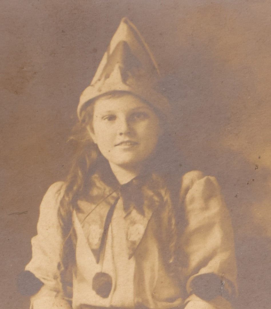 Lot 061 - Antique Photo Of A Young Girl In A Halloween Costume, Black Cats On Hat, Pumpkin Jack-O-Lanterns On Her Skirt, Holding An Animal Mask