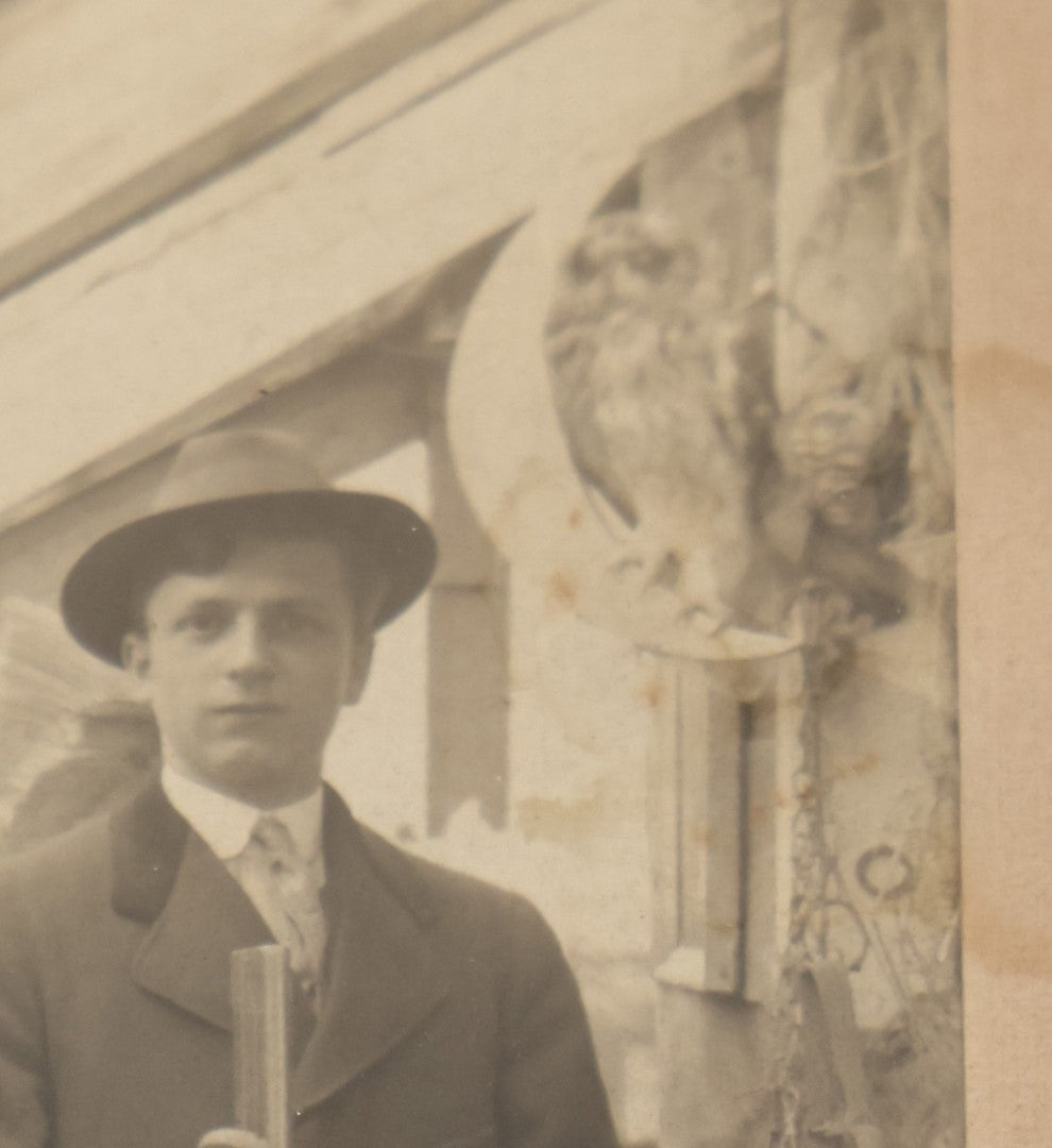 Lot 014 - Antique Boarded Photo Of A Hunter With A Rifle In A Taxidermy Shot, Posing With Buck, Other Mounts Visible Including Beaver, Owl, Etc
