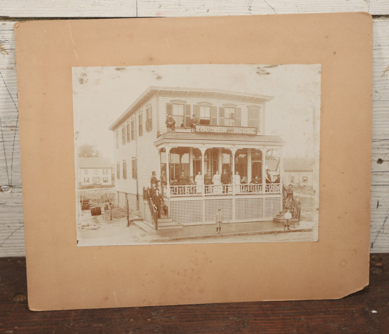 Lot 063 - Antique Boarded Photograph Of Wisconsin House, Possible Inn, With Many Men, Women, And Children On Porch, On Roof