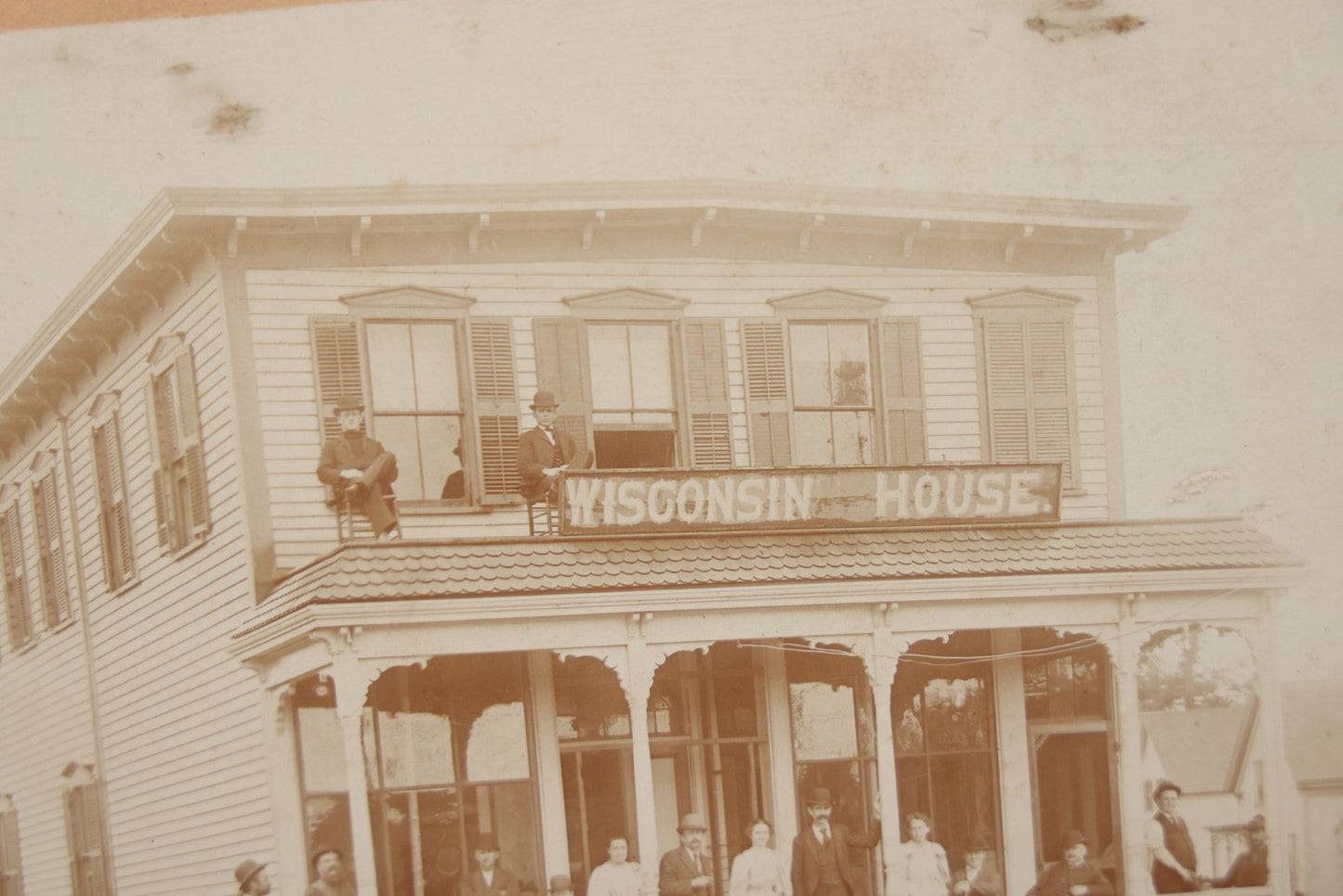Lot 063 - Antique Boarded Photograph Of Wisconsin House, Possible Inn, With Many Men, Women, And Children On Porch, On Roof
