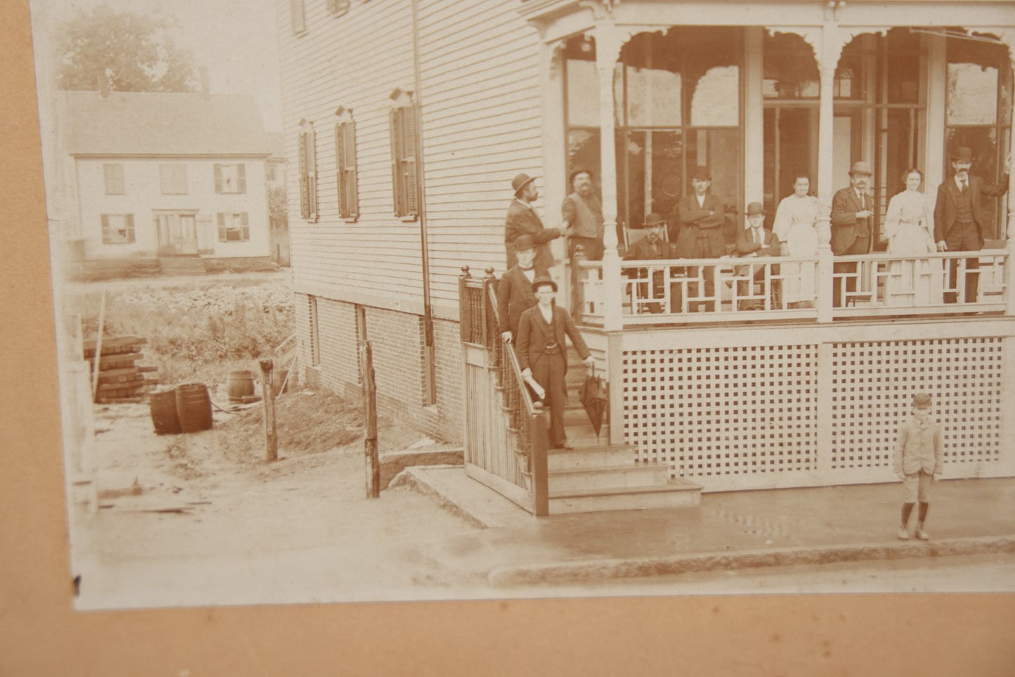 Lot 063 - Antique Boarded Photograph Of Wisconsin House, Possible Inn, With Many Men, Women, And Children On Porch, On Roof