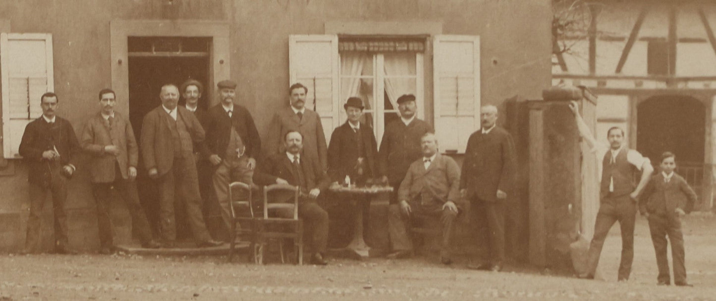 Lot 135 - Antique Boarded Photo Of A Large Group Of Photo Outside Of A Building With A Trade Sign Hanging From It, Horse Drawn Carriage In The Background, Men, Women, And Children, Unknown Location