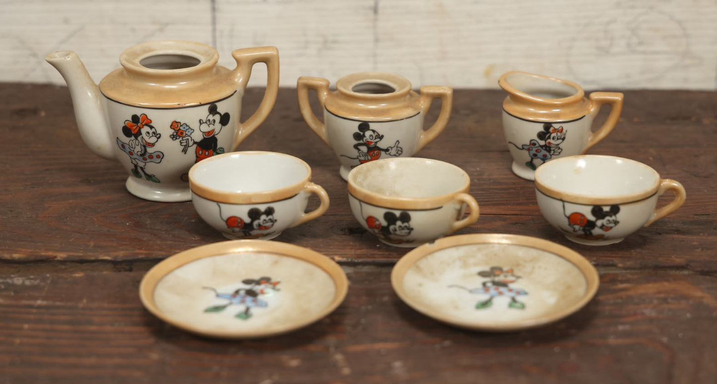 Lot 056 - Grouping Of Eight Vintage Hand Painted Mickey And Minnie Mouse Disney Tea Set Pieces Including Teapot, Creamer, Sugar Bowl, Cups, And Plates, Note Various Chips, Wear, Made In Occupied Japan, Walt Disney Productions