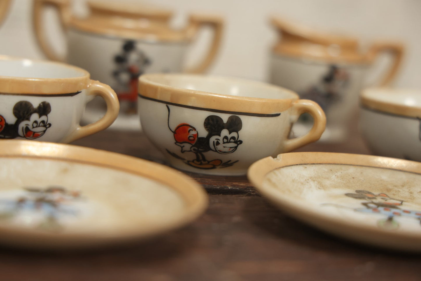 Lot 056 - Grouping Of Eight Vintage Hand Painted Mickey And Minnie Mouse Disney Tea Set Pieces Including Teapot, Creamer, Sugar Bowl, Cups, And Plates, Note Various Chips, Wear, Made In Occupied Japan, Walt Disney Productions