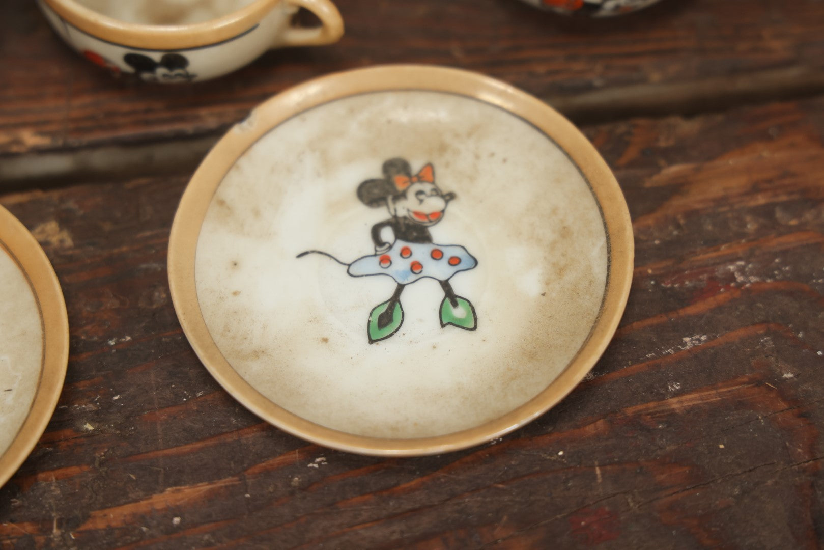 Lot 056 - Grouping Of Eight Vintage Hand Painted Mickey And Minnie Mouse Disney Tea Set Pieces Including Teapot, Creamer, Sugar Bowl, Cups, And Plates, Note Various Chips, Wear, Made In Occupied Japan, Walt Disney Productions