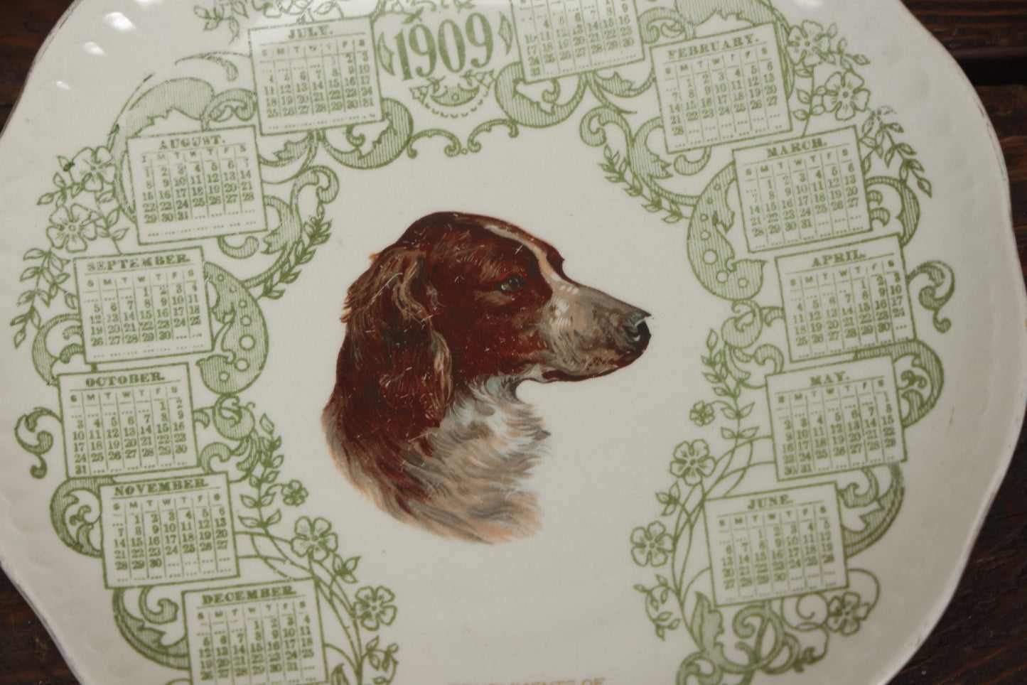 Lot 063 - Antique Porcelain Transferware 1909 Calendar Plate, With Dog, Compliments Of Grange Store, Amherst, Massachusetts, M.C. Co., E.L.O. Markings On Back