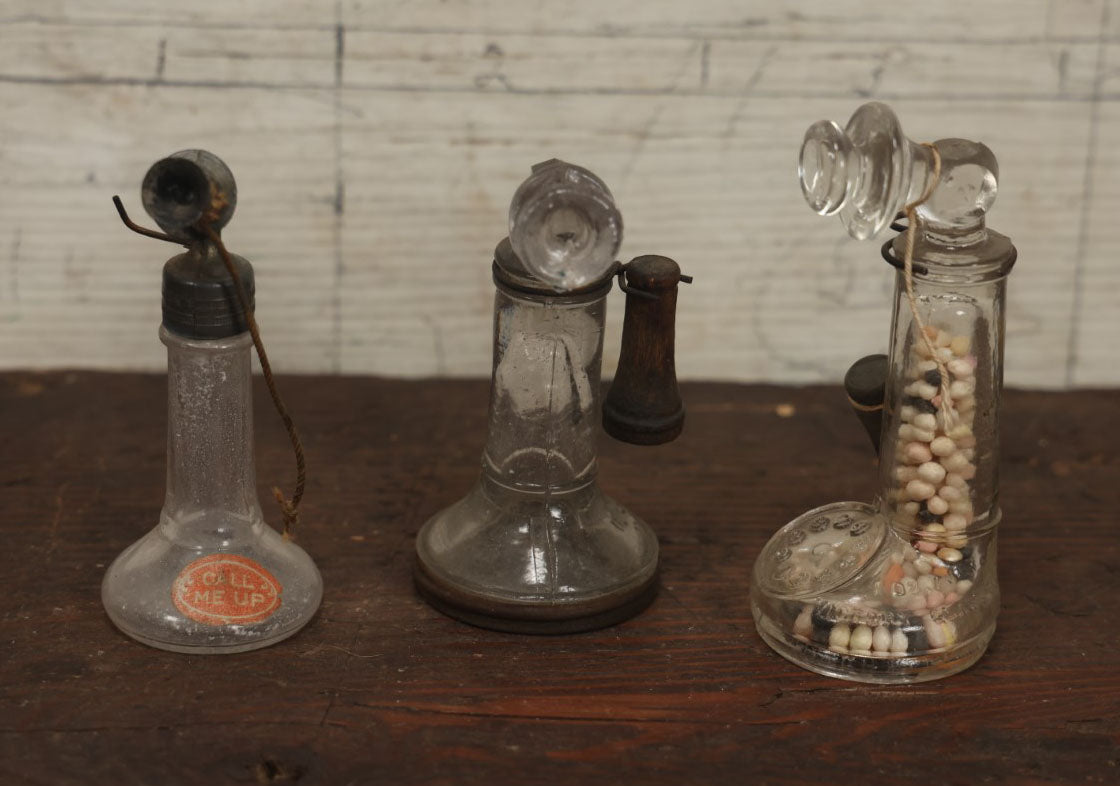 Lot 075 - Grouping Of Three Antique Stick Telephone Glass Candy Containers, Two With Wooden Phones, One With Original Candy Contents, By Victory Glass Company, Jeannette, Pennsylvania