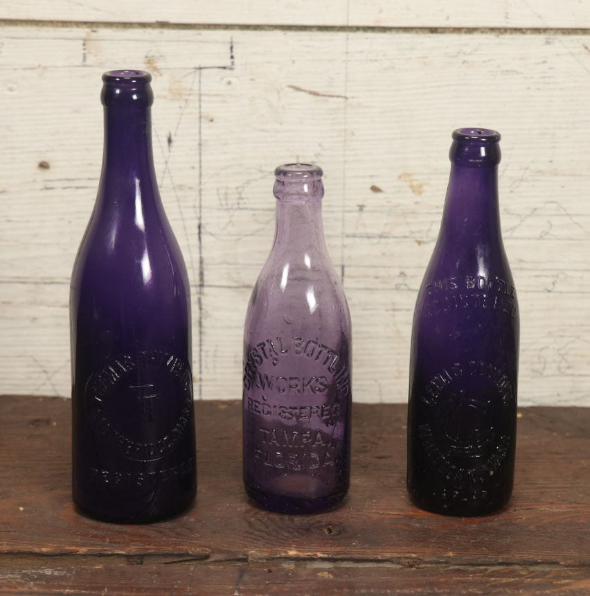 Lot 076 - Grouping Of Three Antique Deep Purple Colored Glass Bottles, Crystal Bottling Works, Tampa, Florida, Lewis Groulding, Whitman, Massachusetts, And Thomas Thimblin, Southbridge, Massachusetts