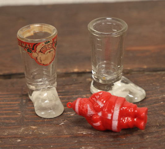 Lot 086 - Three Piece Vintage Christmas Grouping Including Two Glass Santa Boots And A Hard Red Plastic Santa Claus Light Bulb