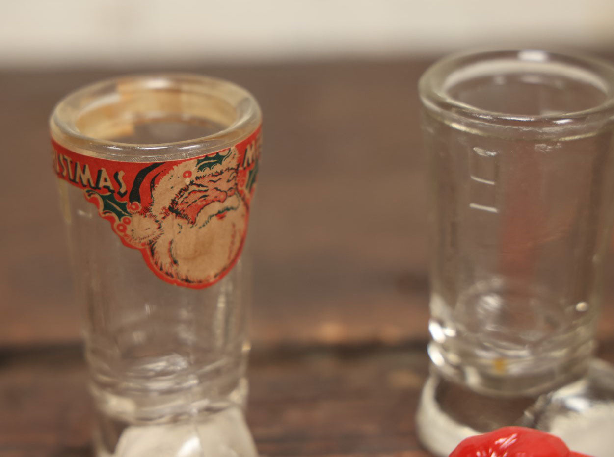 Lot 086 - Three Piece Vintage Christmas Grouping Including Two Glass Santa Boots And A Hard Red Plastic Santa Claus Light Bulb