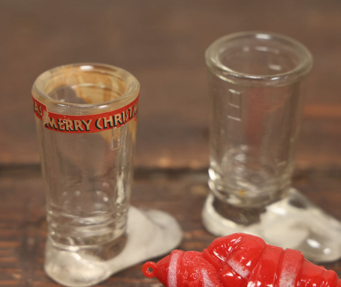 Lot 086 - Three Piece Vintage Christmas Grouping Including Two Glass Santa Boots And A Hard Red Plastic Santa Claus Light Bulb