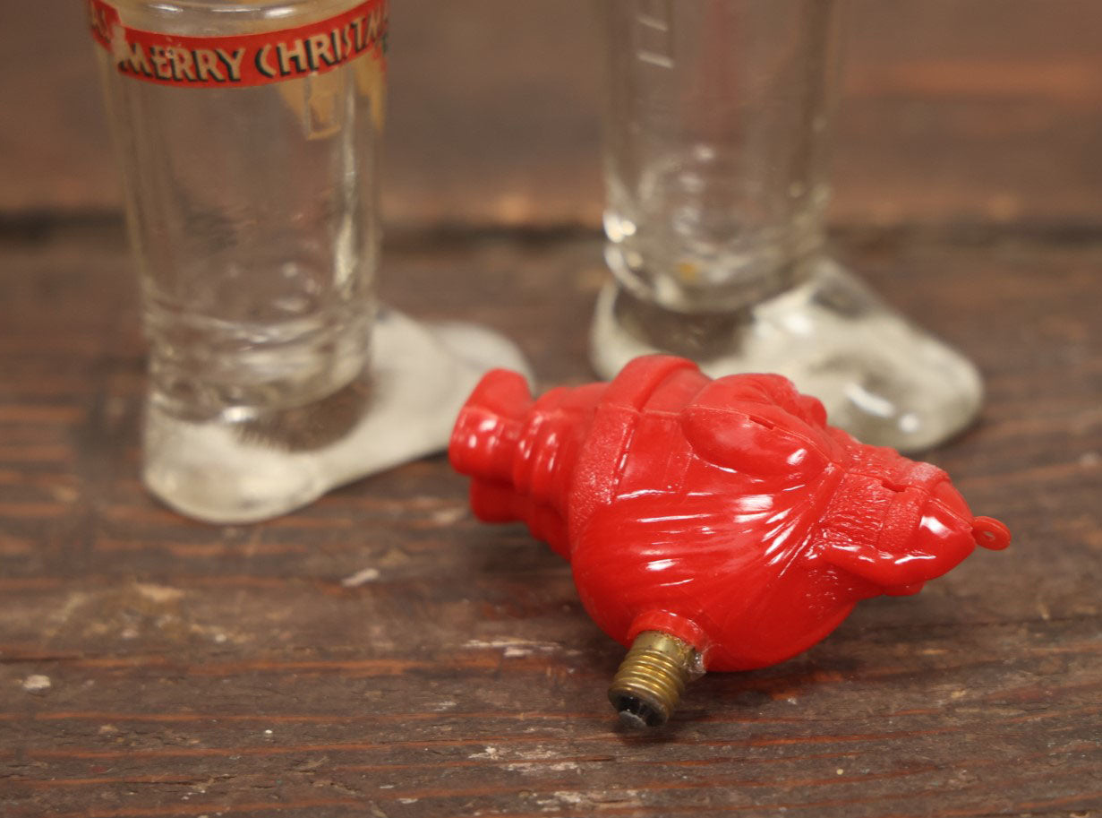 Lot 086 - Three Piece Vintage Christmas Grouping Including Two Glass Santa Boots And A Hard Red Plastic Santa Claus Light Bulb