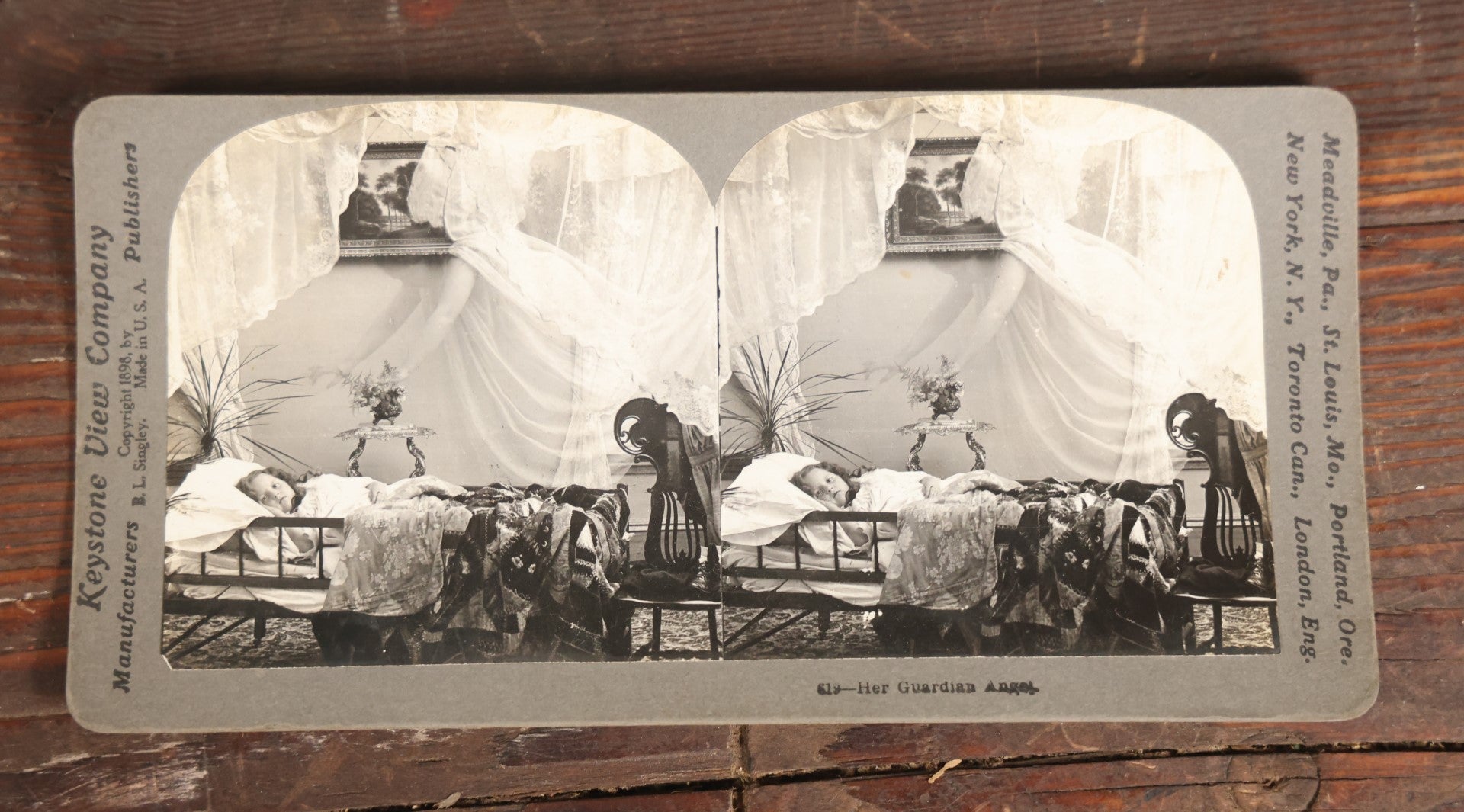 Lot 127 - Antique Spirit Photograph Stereo Card, "Her Guardian Angel" Featuring Ghostly Angel Over Sleeping Child, By Keystone View Company, Copyright 1898