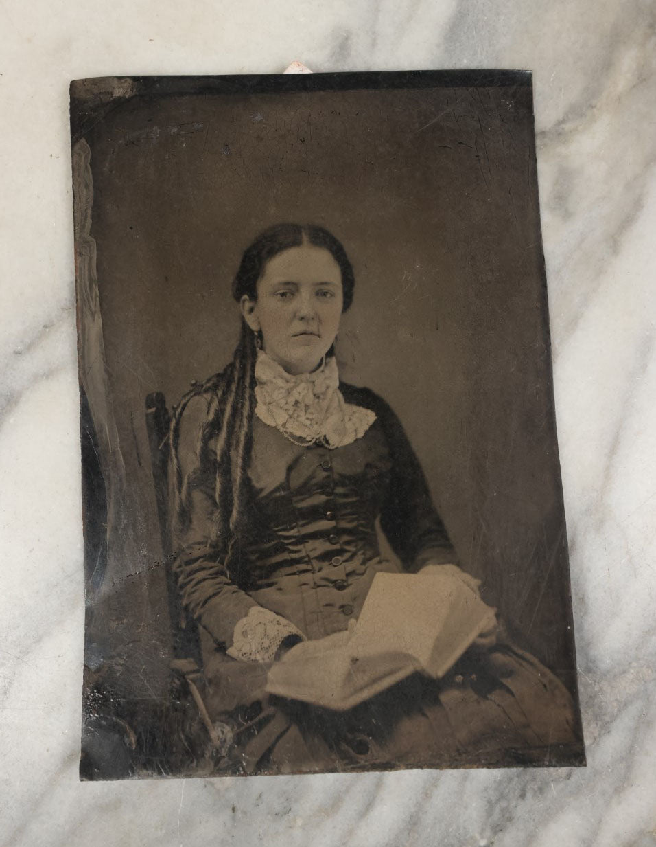 Lot 004 - Antique 1/2 Plate Tintype Photograph Of A Young Woman With An Open Book In Her Lap, Long Curls In Her Hair