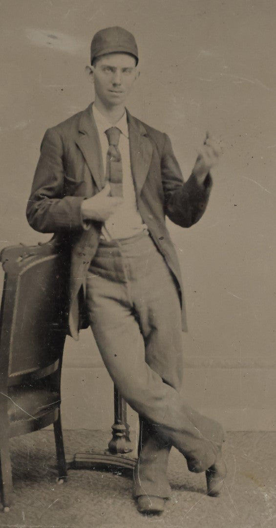 Lot 008 - Antique Tintype Photo Of A Young Man In A Cap, Short Tie, Making Hand Gesture