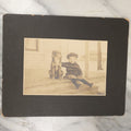 Lot 017 - Antique Boarded Photograph Of A Young Boy In A Hat Sitting On The Front Porch Stoop With His Dog, Identified As Floyd Clement, Jr.