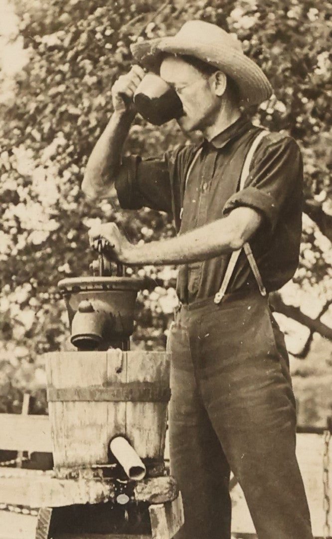 Lot 022 - Antique Boarded Occupational Photograph Of A Man Preparing A Beverage With A Press, Possible Moonshine Or Wine Making