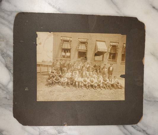 Lot 024 - Antique Boarded Occupational Photograph Of A Group Of Laborers Outside Of A Commercial Building, Note Ladies In Window, Striped Awnings