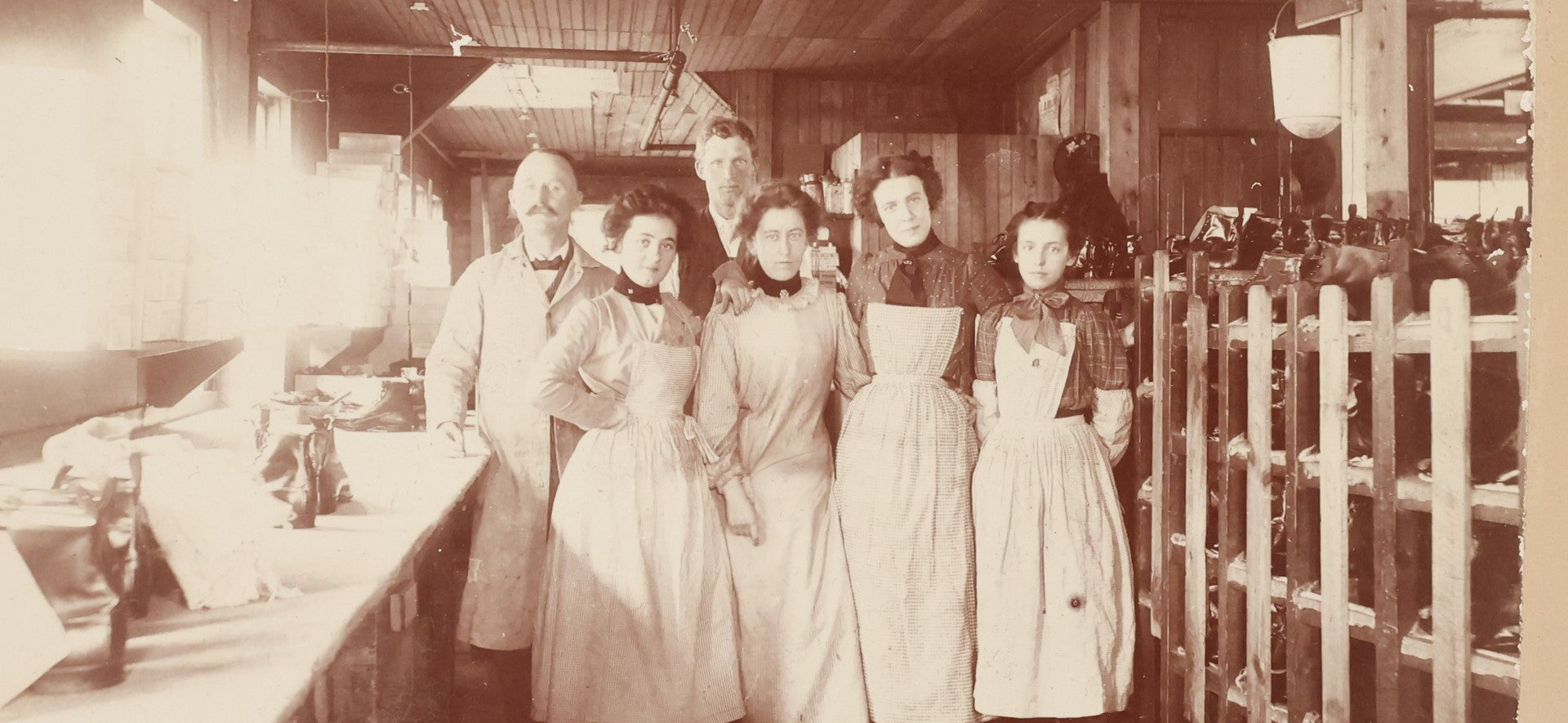 Lot 025 - Antique Boarded Occupational Photograph Of Four Women And Two Men Working In A Boot And Shoe Factory, Many Shoes Visible In Photo