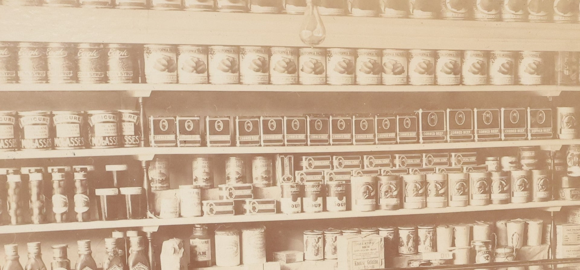 Lot 026 - Antique Boarded Occupational Photograph Of A Shopkeeper In A General Store, Identified As C.R. Johnson, 1907, Products Visible, Including Campbell's Soup Cans