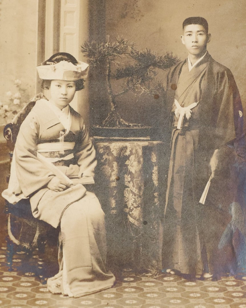 Lot 036 - Antique Boarded Photo Of A Young Chinese Couple, Man And Woman In Traditional Dress, Text On Back Of Board Translates To "Photo Post"