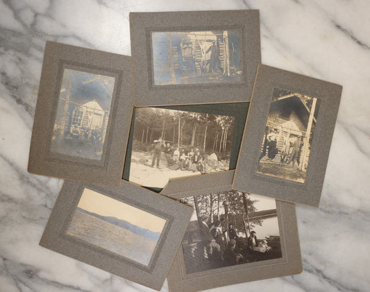 Lot 038 - Grouping Of Six Antique Boarded Photographs Related To Hunting And The Outdoors, Including Strung Up Deer, Group Photo With Man Shooting Rifle, Photo With People Holding Oars, Lake