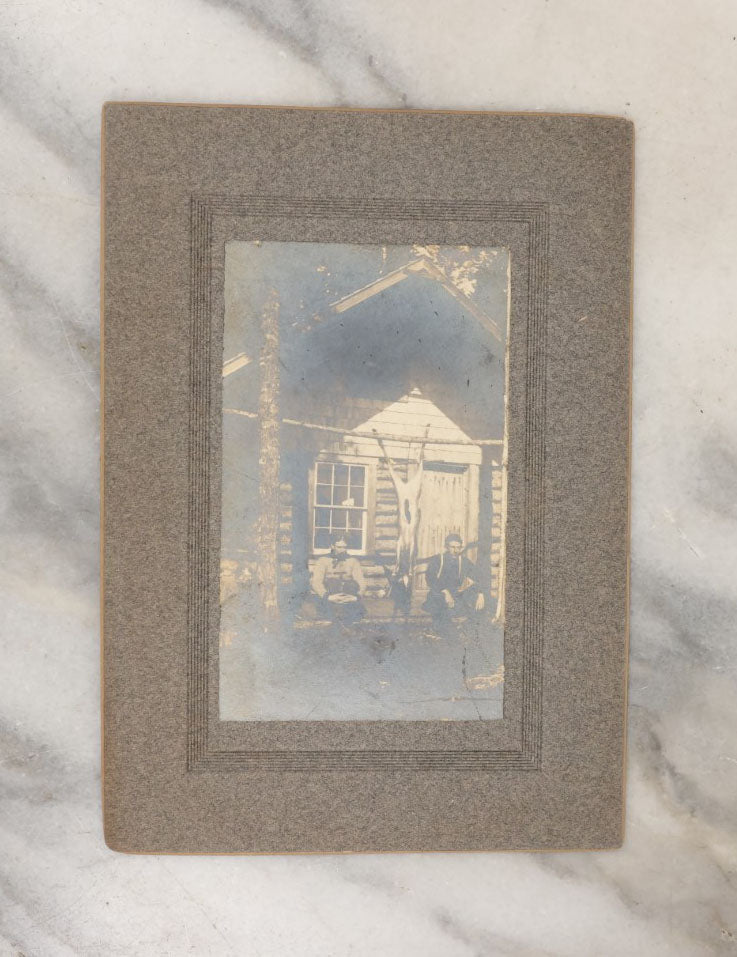 Lot 038 - Grouping Of Six Antique Boarded Photographs Related To Hunting And The Outdoors, Including Strung Up Deer, Group Photo With Man Shooting Rifle, Photo With People Holding Oars, Lake