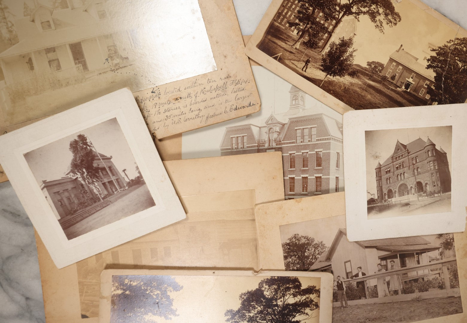 Lot 044 - Grouping Of Eight Photographs Of The Exteriors Of Buildings And Homes, Municipal Buildings And More, Including Mountain Home Of Joshua Edwards, Kalispell, Montana, 1897