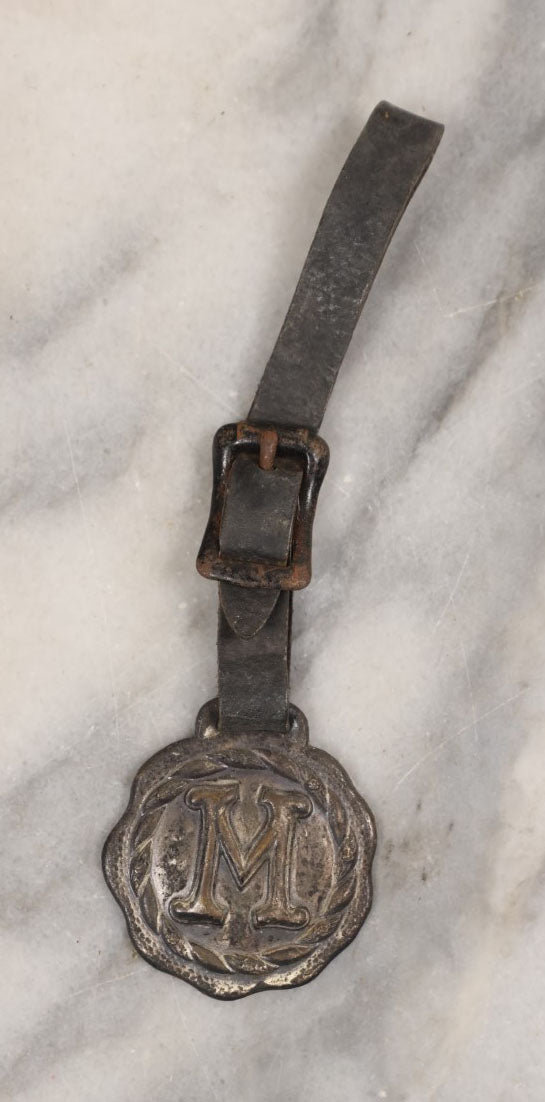 Lot 154 - Single Junk Drawer Finding, Letter "M" Watch Fob With Leather Strap