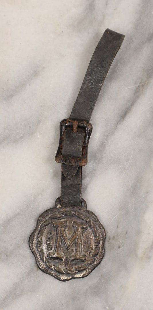 Lot 154 - Single Junk Drawer Finding, Letter "M" Watch Fob With Leather Strap