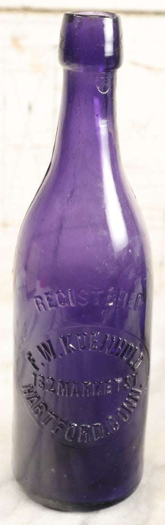 Lot 196 - Grouping Of Three Vintage And Antique Purple Glass Bottles, Including F.W. Kuenhold, Hartford, Connecticut, Sampson Springs Co., South Boston, And Brockton Bottling Co, Massachusetts