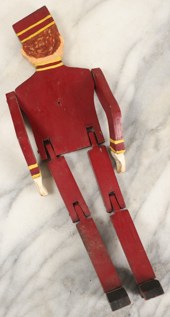 Lot 080 - Vintage Folk Art Wood Cut Bellhop Or Trainman Jointed Figurine, Hand Cut And Hand Painted, Red Clothes
