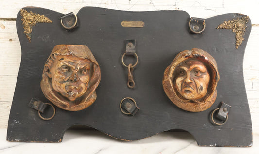 Lot 093 - Antique Chalkware Friar Heads Wall Hanging Match Safe And Match Strike, Matches Go In Friar's Heads, On Wooden Plaque With Metal Adornments, Note Various Chipping Losses