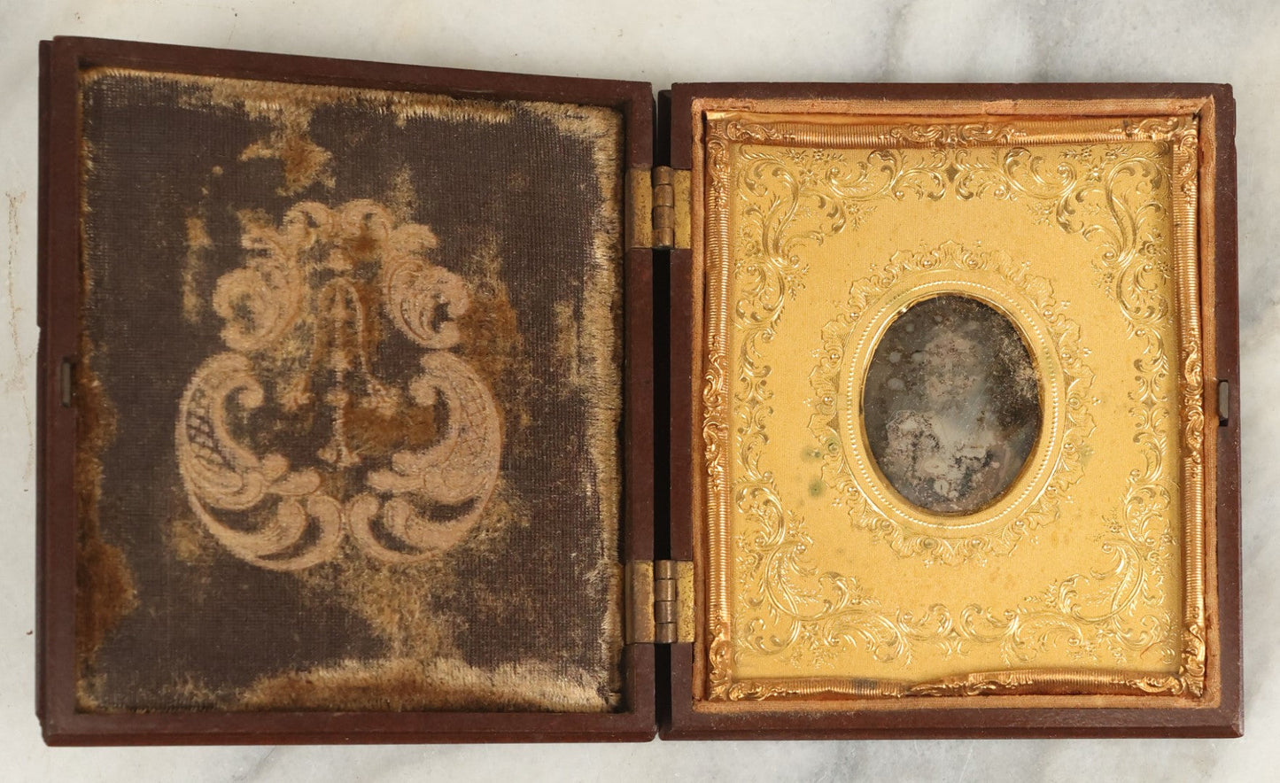 Lot 098 - Antique 1/6th Plate Daguerreotype Photograph Of A Young Baby In A Thermoplastic Case With Deep Brass Mat, Note Heavy Wear, Degradation To Photo, But Baby's Face Still Visible