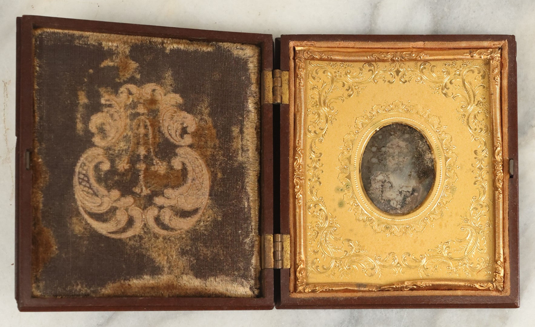 Lot 098 - Antique 1/6th Plate Daguerreotype Photograph Of A Young Baby In A Thermoplastic Case With Deep Brass Mat, Note Heavy Wear, Degradation To Photo, But Baby's Face Still Visible