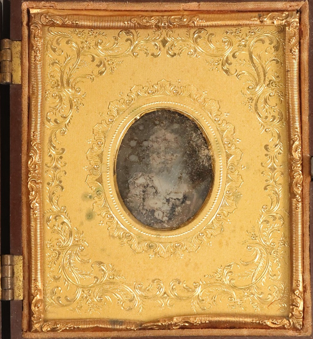 Lot 098 - Antique 1/6th Plate Daguerreotype Photograph Of A Young Baby In A Thermoplastic Case With Deep Brass Mat, Note Heavy Wear, Degradation To Photo, But Baby's Face Still Visible