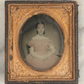Lot 110 - Antique 1/6th Plate Ambrotype Of A Pretty Young Girl In A Pink Tinted Off-The-Shoulders Dress, Gold Tinted Bracelet, In Half Leatherette Case