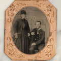 Lot 116 - Antique Matted Tintype Photograph Of A Younger Couple, Woman In Long Dress With Over Shirt, Man In Suit, With Tinted Cheeks, Man Seated