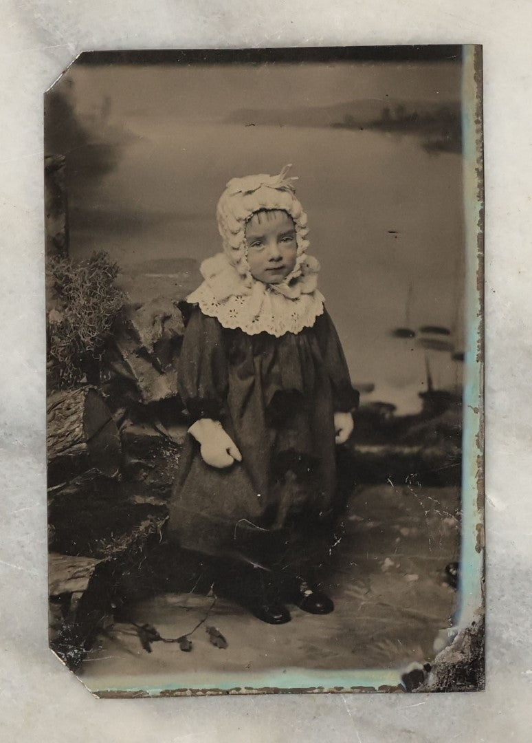 Lot 131 - Grouping Of Seven Antique Tintype Photographs Of Babies And Children, Including Smiling Baby With Tinted Yellow Waist Ribbon, Toddler In Winter Clothes With Gloves, And More