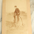 Lot 074 - Antique Boarded Photograph Of A Man In A Cap On A High Wheel Penny Farthing Bicycle
