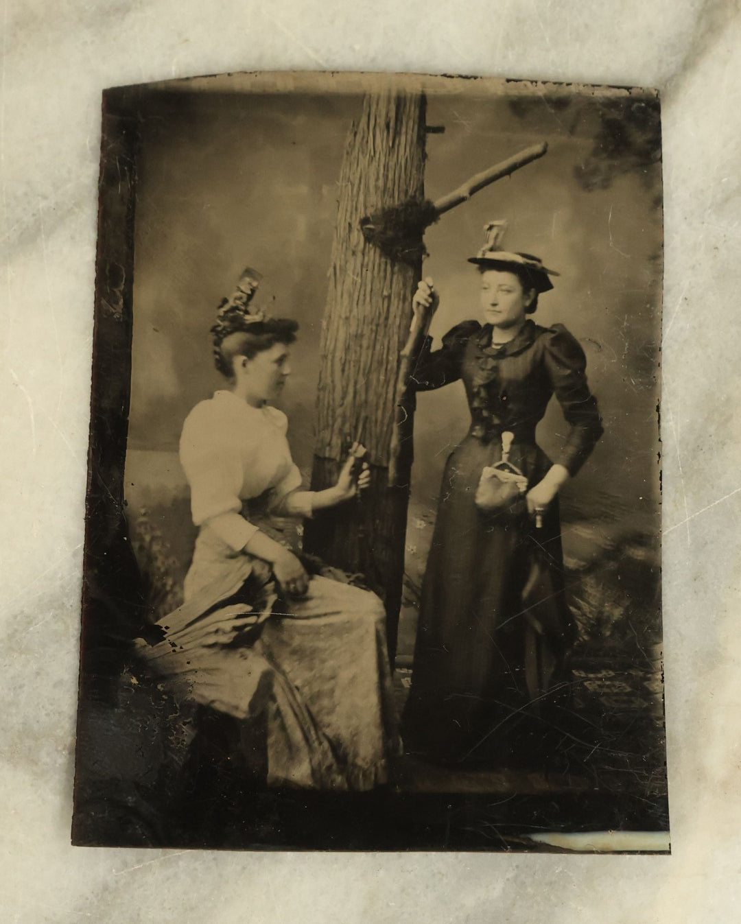 Lot 094 - Single Antique Tintype Photograph Of Two Women Posing With A Tree And Their Walking Sticks, Parasols