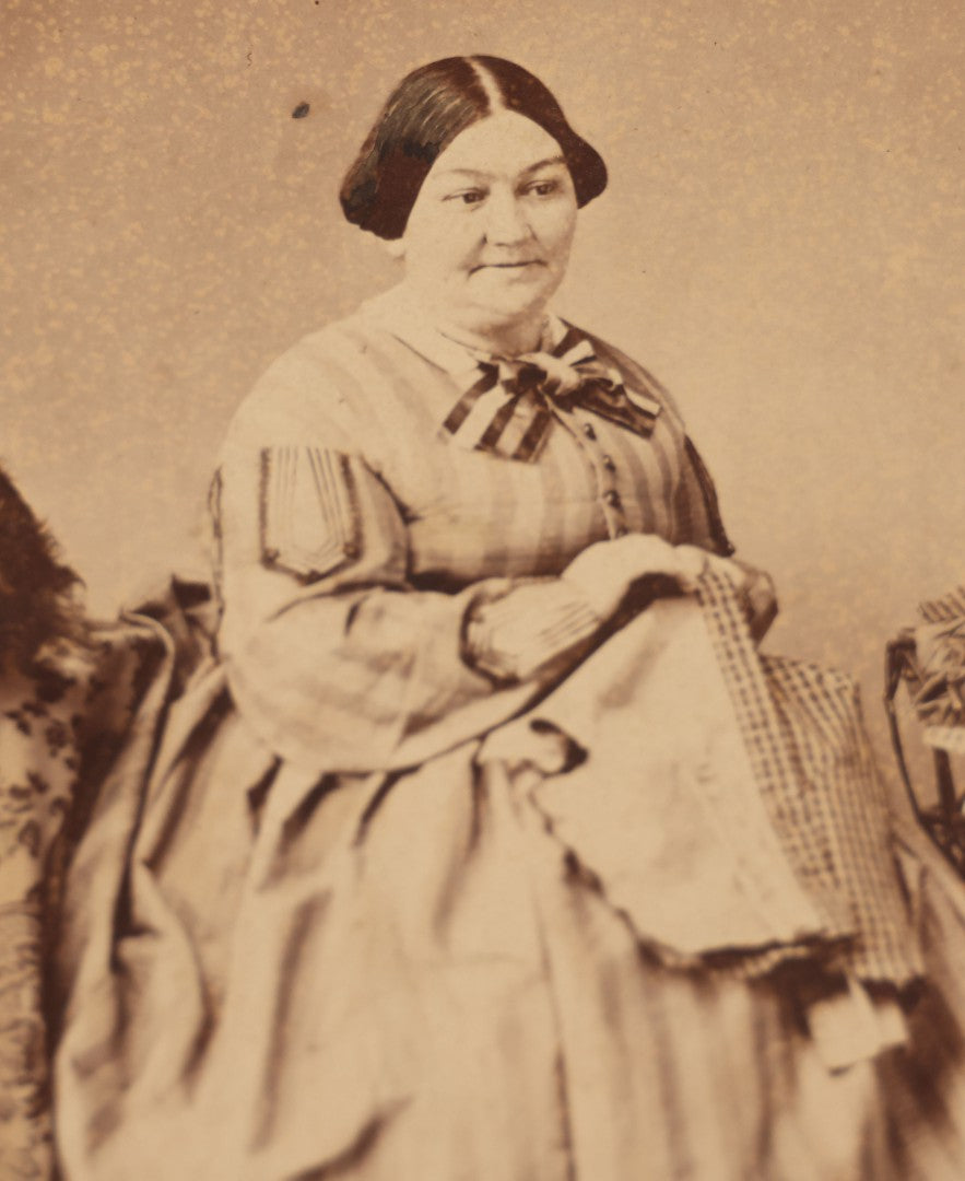 Lot 069 - Antique Matted Occupational Photograph Of An Adult Woman Seamstress, Pictured With Sewing Stand, And Scraggly Little Black Dog On Table To The Left, C.L. Obst Photographer, Pittsfield, Illinois