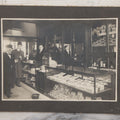 Lot 109 - Antique Boarded Photo Of A Tobacco, Cigar Shop, With Man Behind Counter, Customers In Bowler Hats, Various Cigar Brands