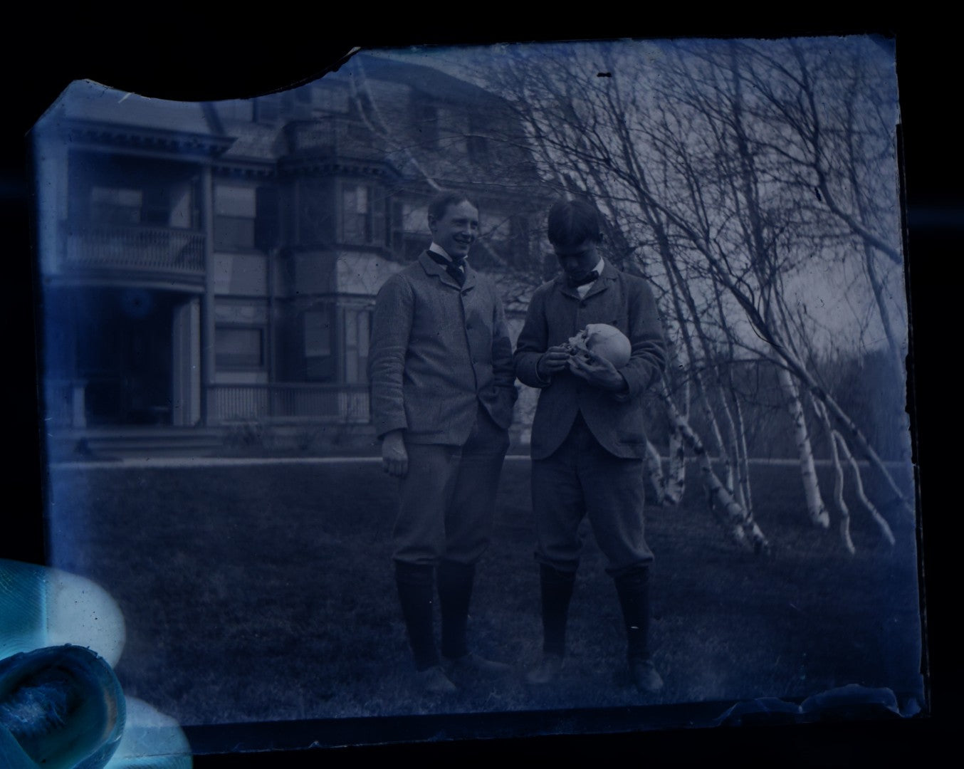 Lot 061 - Single Antique Glass Negative Plate, Man Holding Real Human Skull, With Grinning Man To Left, In Front Of House, Note Edge Cracks (First Photo Is Inverted)