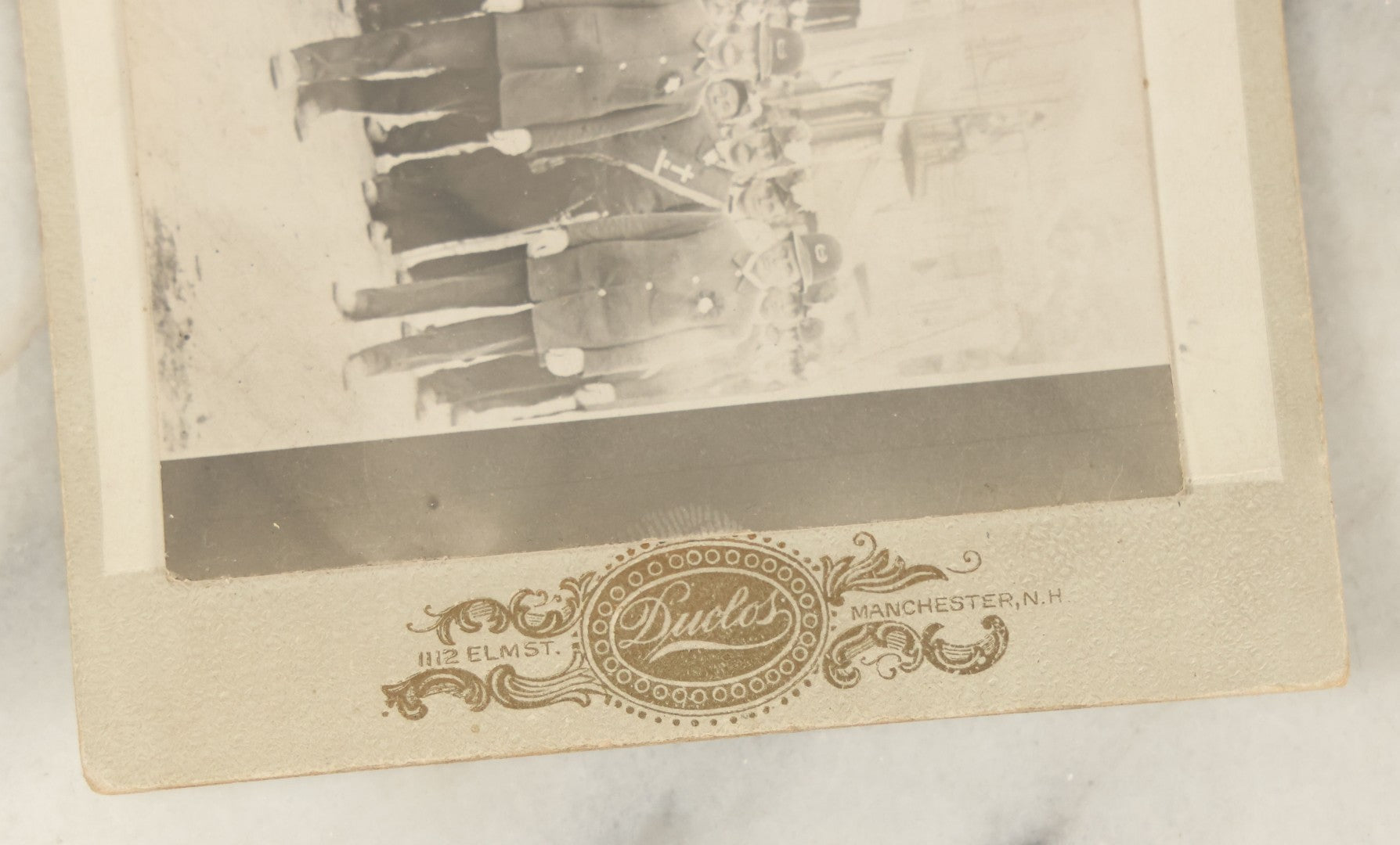 Lot 113 - Antique Photo Mounted On Cabinet Card (Not Original To Card) Of A Fraternal Memorial Parade, Possible Funeral, With Men In Hats, "In Memoriam" Sashes, Mark From Duclor Photographer, Manchester, New Hampshire