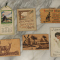 Lot 120 - Grouping Of Six Pieces Of Vintage And Antique Ephemera Including Wooden Postcards, Fair Skies Booklet, Advertising Calendar, And More