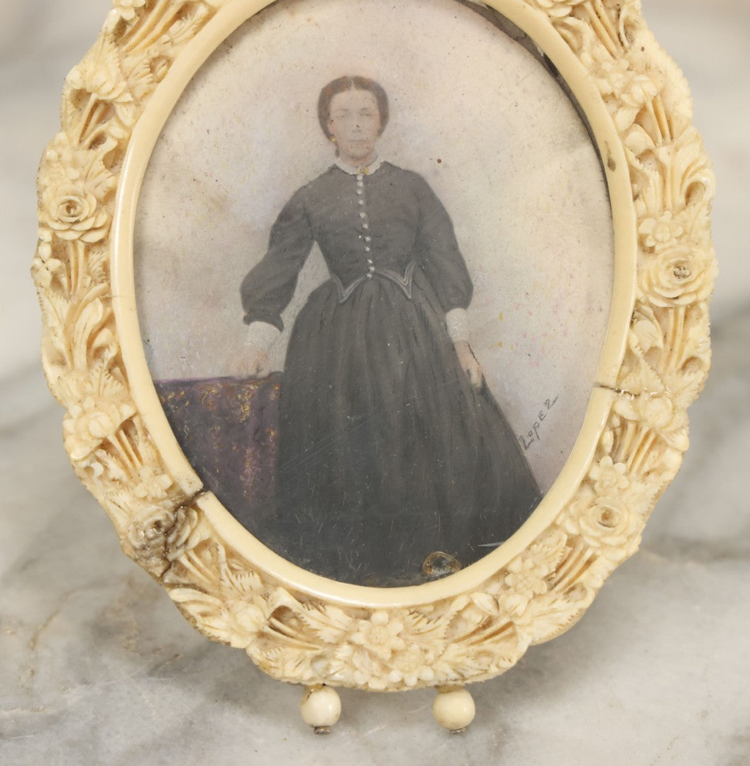 Lot 046 - Antique Painted Over Photo Portrait Miniature Of A Woman, Signed Lopez, In Ornate Carved Scrimshaw Bone Floral Frame, Note Repairs