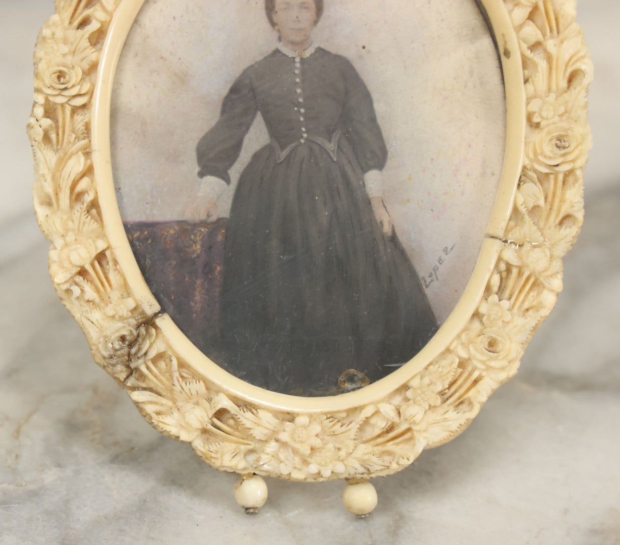 Lot 046 - Antique Painted Over Photo Portrait Miniature Of A Woman, Signed Lopez, In Ornate Carved Scrimshaw Bone Floral Frame, Note Repairs