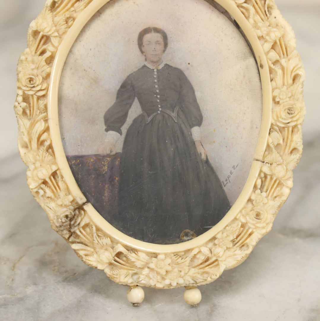 Lot 046 - Antique Painted Over Photo Portrait Miniature Of A Woman, Signed Lopez, In Ornate Carved Scrimshaw Bone Floral Frame, Note Repairs