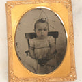 Lot 086 - Antique 1/9th Plate Ruby Ambrotype Photograph Of A Baby In A White Dress Seated In A Chair, Slack Jawed Expression, Note Scratches
